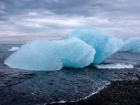 Blaugrün schimmernde Eisklötze im flachen Uferbereich des Diamond Beach - Südisland